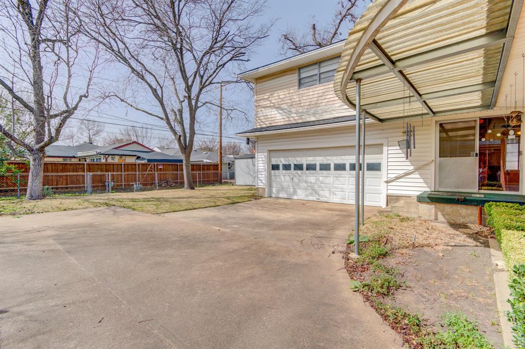 9203 Lindaro Lane Dallas, TX 75228 - Photo 29 of 32 View of side of home featuring a garage and concrete driveway