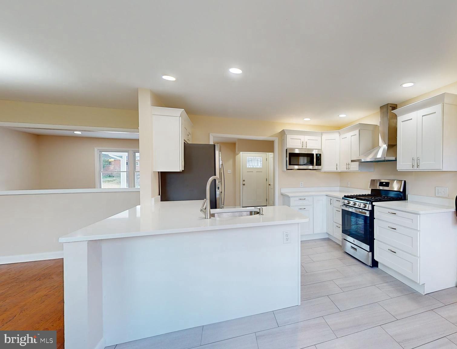 a large kitchen with stainless steel appliances lots of counter space and a sink