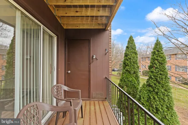 a view of a brick house with large windows and trees