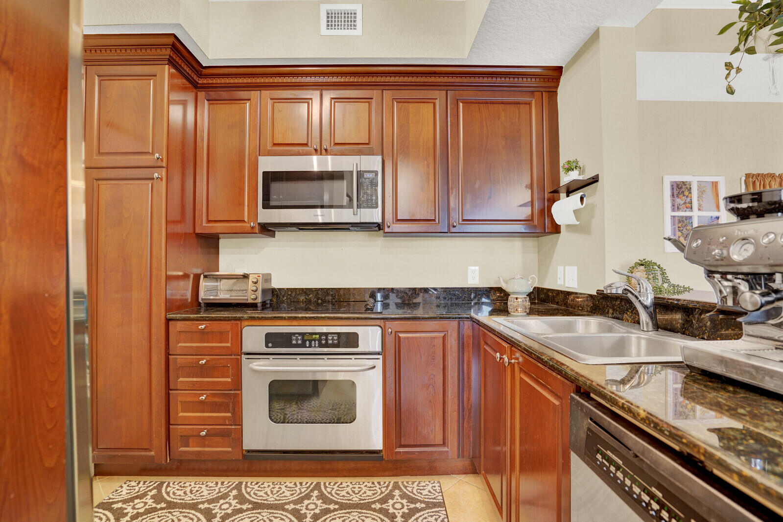 1201 Renaissance Way, Unit 201 Boynton Beach, FL 33426 - Photo 15 of 29 a kitchen with granite countertop a sink stove and microwave