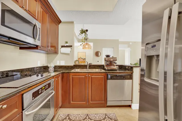 a kitchen with stainless steel appliances granite countertop a stove a sink and a refrigerator