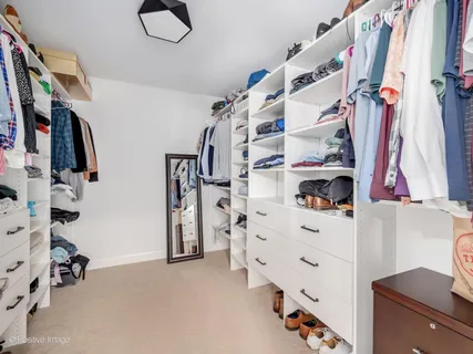 a view of walk in closet with clothes and shoes