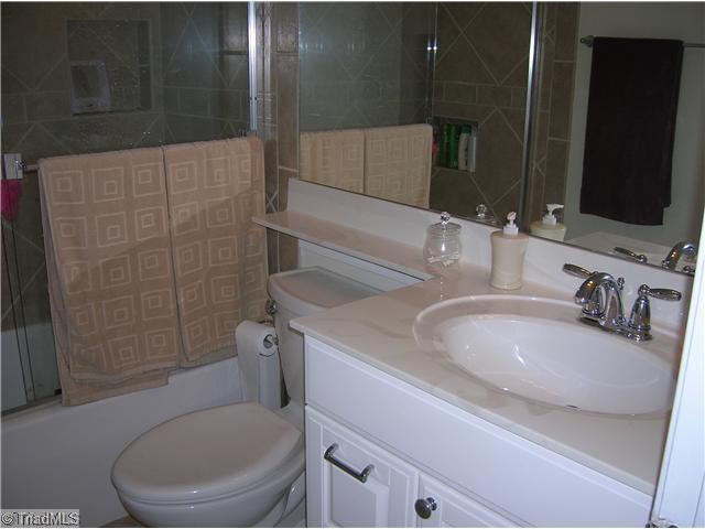 5105 Amberhill Drive Greensboro, NC 27455 - Photo 7 of 11 Other Bath. The hall bath has been updated with new cabinetry, toilet, tile, shower doors!