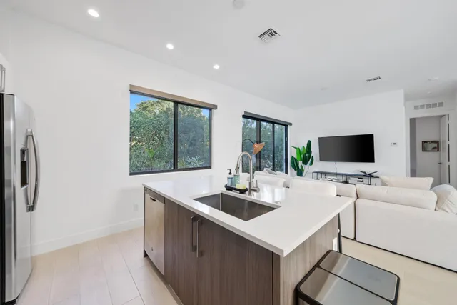 a kitchen with stainless steel appliances a stove a refrigerator a sink a stove and cabinets