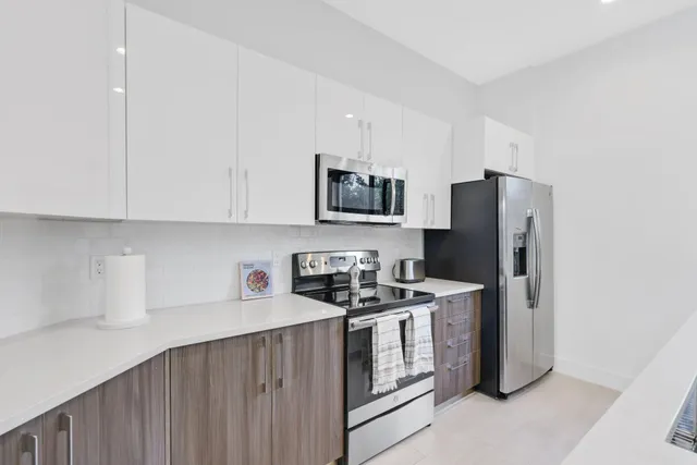 a kitchen with stainless steel appliances a refrigerator sink and microwave