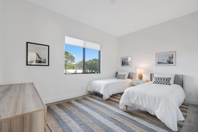 a bedroom with two beds and a potted plant