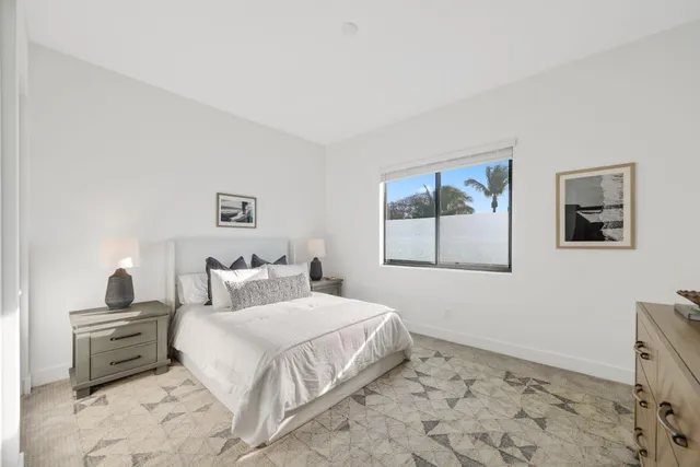 a bedroom with a bed a mirror on dresser and a chandelier