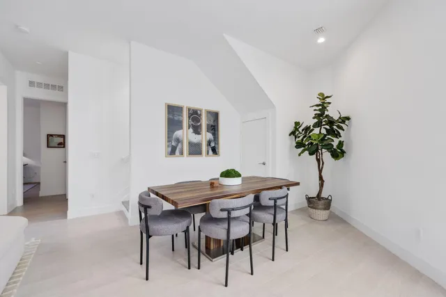 a kitchen with stainless steel appliances a table and chairs in it