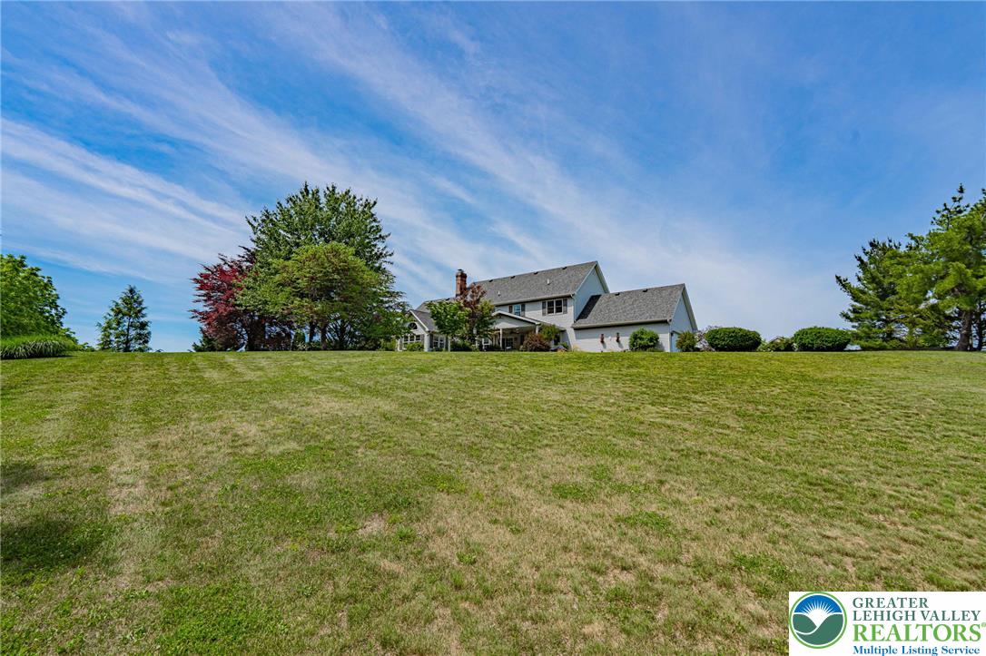 4542 Springfield Drive Coplay, PA 18037 - Photo 73 of 89 A spacious grassy expanse leads up to a serene residence nestled among mature trees.