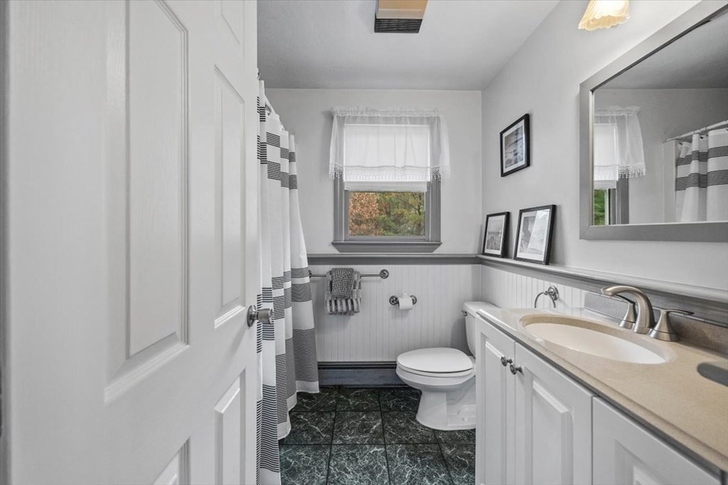 5 Stacey Road Middleboro, MA 02346 - Photo 25 of 40 a bathroom with a granite countertop toilet a sink a mirror and a window