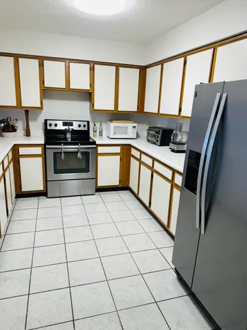 a kitchen with stainless steel appliances granite countertop a refrigerator stove top oven and sink