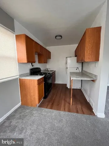 a kitchen with stainless steel appliances wooden cabinets a stove a sink and a refrigerator