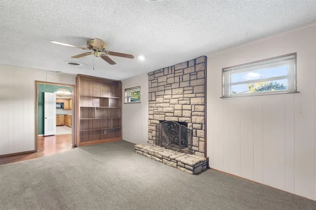 a view of empty room with fireplace and windows