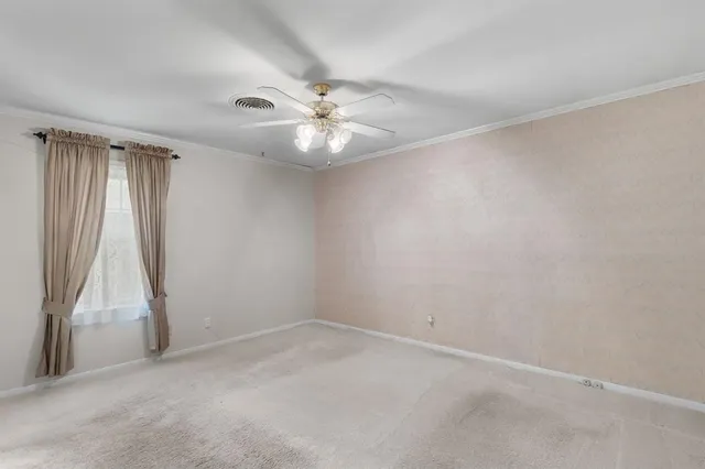 an empty room with a white cabinet and a ceiling fan