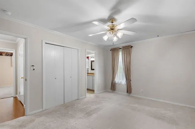 an empty room with closet and fan
