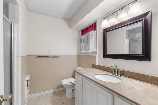 a bathroom with a granite countertop toilet sink and mirror