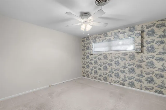 en empty room with windows and ceiling fan