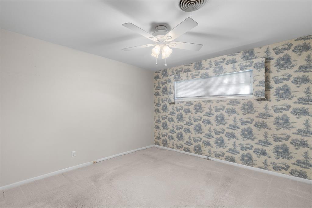 4906 Greenbriar Road Wichita Falls, TX 76302 - Photo 22 of 33 en empty room with windows and ceiling fan
