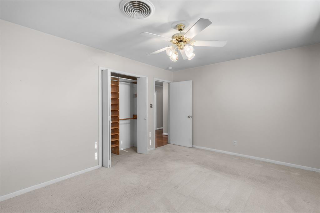 4906 Greenbriar Road Wichita Falls, TX 76302 - Photo 29 of 33 an empty room with a chandelier fan and windows