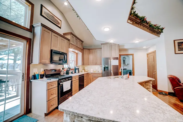 a kitchen with a refrigerator and a stove top oven
