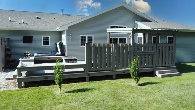 a view of a patio with table and chairs and wooden fence