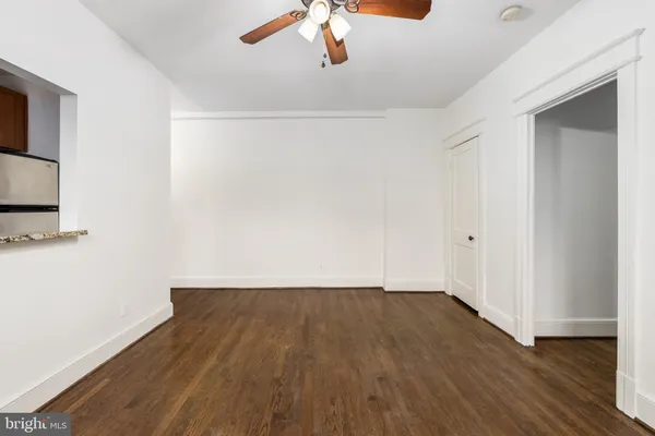 a view of a room with wooden floor and a ceiling fan