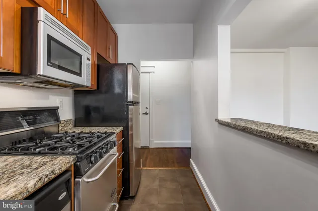 a kitchen with stainless steel appliances kitchen island a stove and a microwave