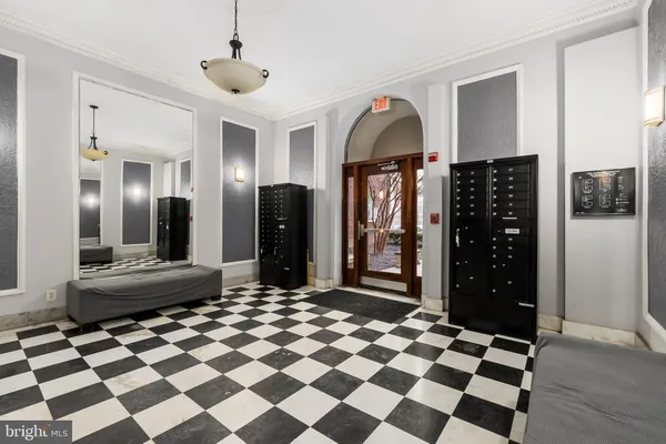 a living room with a black white checkered floor with couches chair and a coffee table