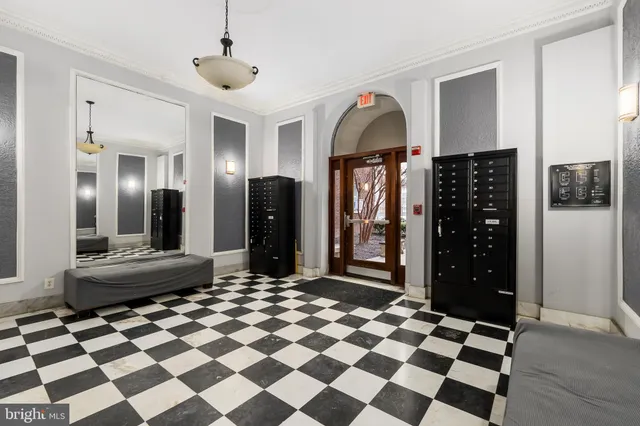 a living room with a black white checkered floor with couches chair and a coffee table