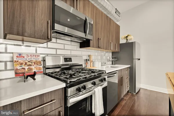 a kitchen with stainless steel appliances a stove and a microwave