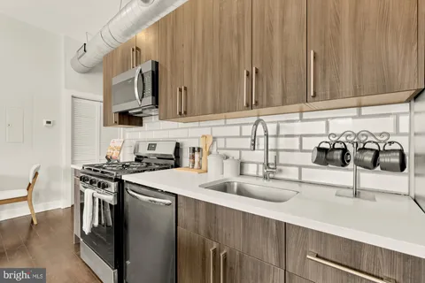 a kitchen with stainless steel appliances granite countertop a sink stove and cabinets