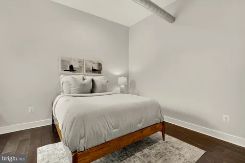 a bedroom with a bed and wooden floor