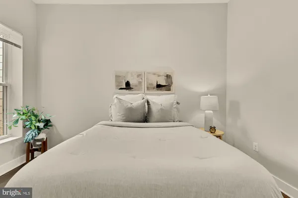 a bedroom with a bed and a potted plant