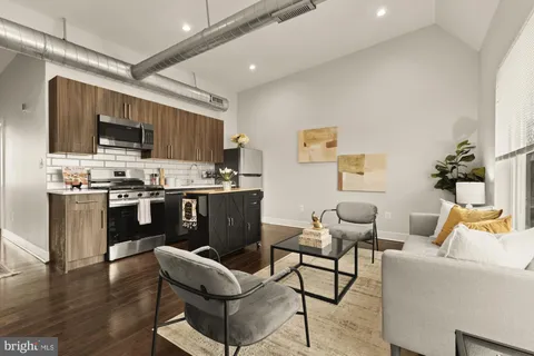 a kitchen with stainless steel appliances kitchen island granite countertop a stove a refrigerator a sink dishwasher and a dining table with wooden floor