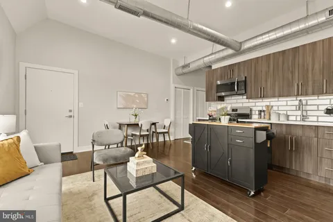 a living room with stainless steel appliances kitchen island granite countertop furniture and a view of kitchen