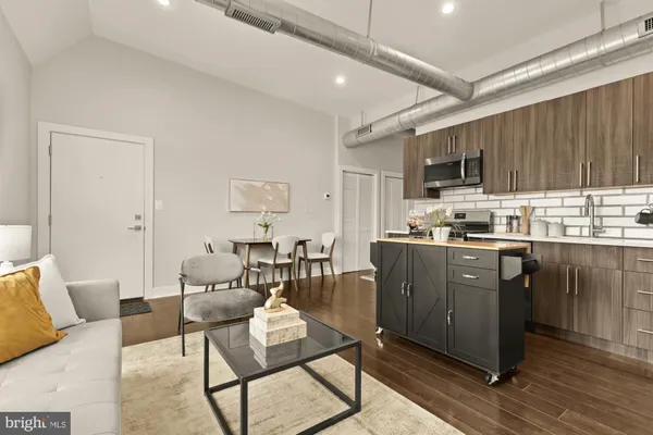 a living room with stainless steel appliances kitchen island granite countertop furniture and a view of kitchen