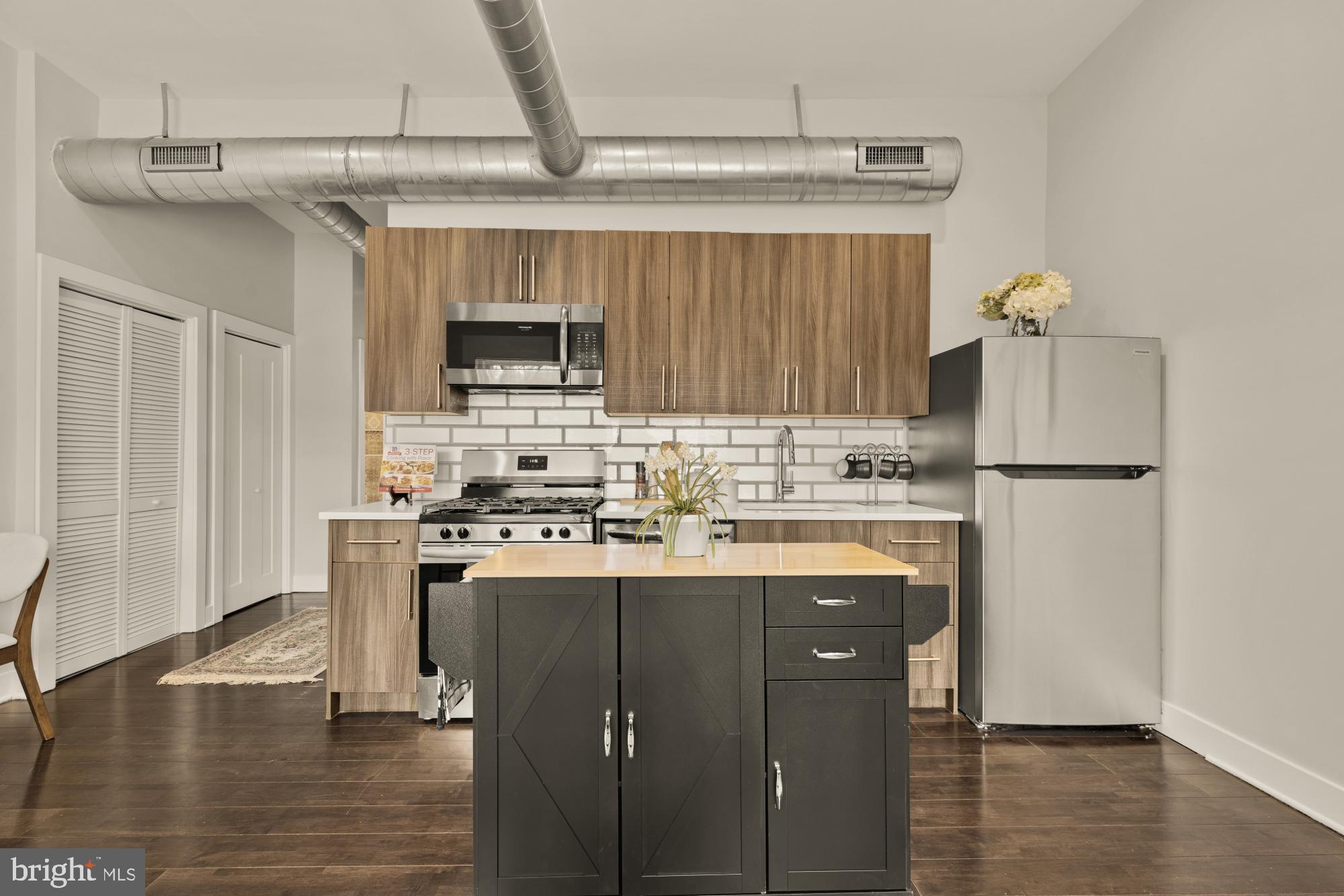 1605 F Street Northeast, Unit 4 Washington, DC 20002 - Photo 10 of 25 a kitchen with stainless steel appliances granite countertop a stove and a refrigerator