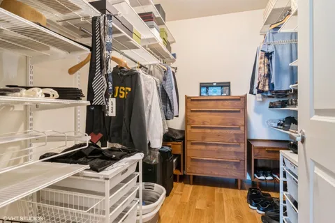 a view of walk in closet with clothes and shoes