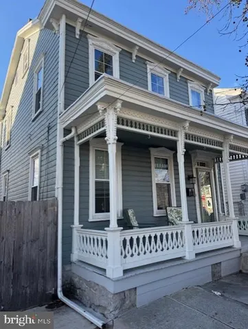 a view of a house with entrance and a bench