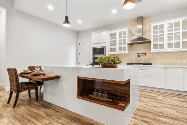 a kitchen with a stove and a wooden floor