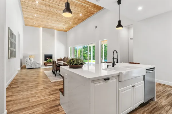 a large room with kitchen island a sink stainless steel appliances and furniture