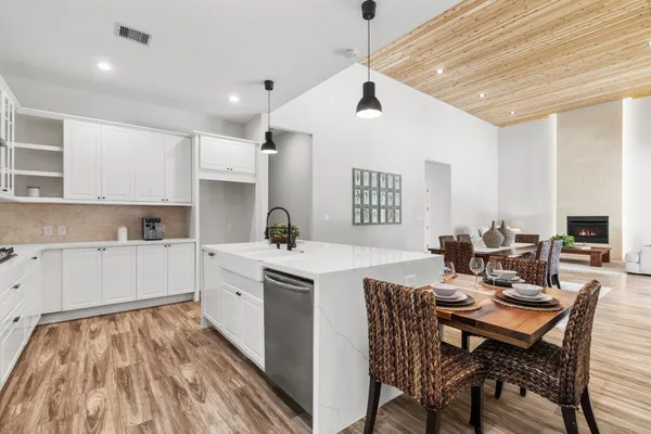 a kitchen that has a lot of cabinets in it with a dining table and chairs