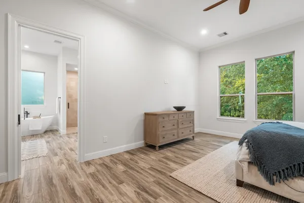 a bedroom with a bed and large windows