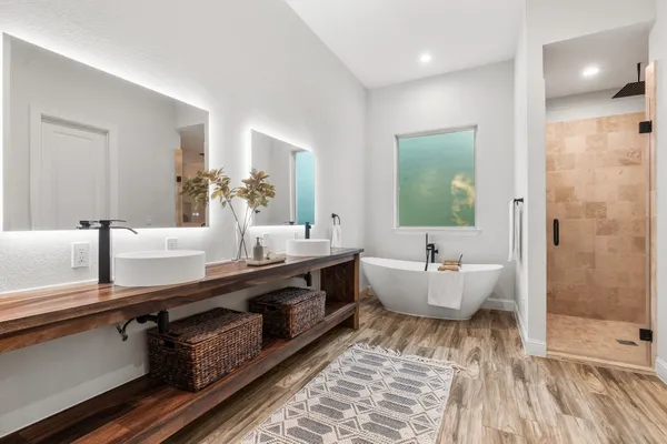 a bathroom with a double vanity sink a mirror and a bathtub