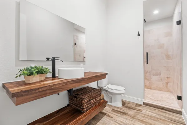 a bathroom with a sink a toilet and shower