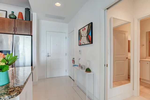 a hallway with painting on the wall and a potted plant