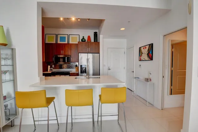 a view of kitchen with stainless steel appliances kitchen island granite countertop a table and chairs in it