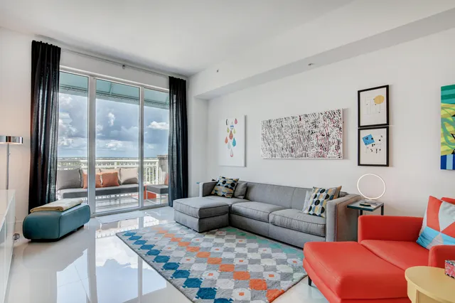 a living room with furniture and a floor to ceiling window