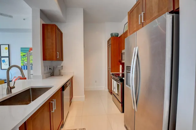 a kitchen with stainless steel appliances granite countertop a refrigerator and a sink