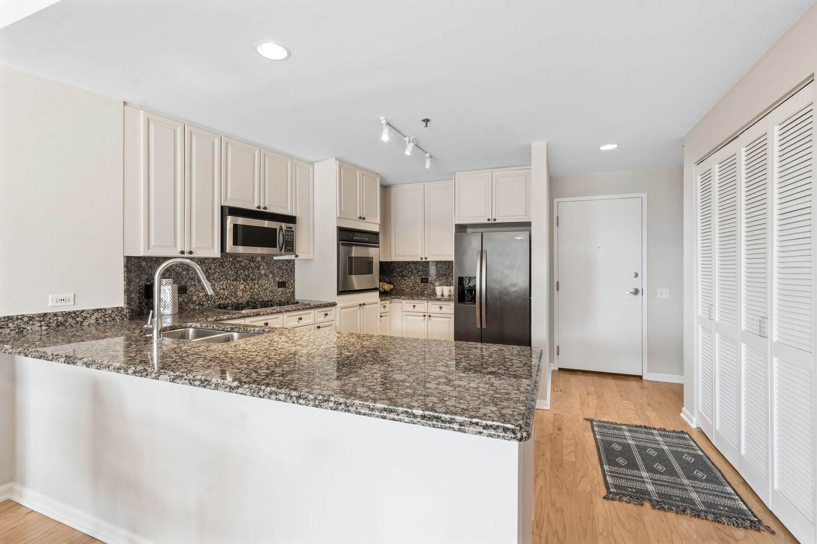 1515 South Prairie Avenue, Unit 508 Chicago, IL 60605 - Photo 5 of 22 a kitchen with granite countertop a refrigerator a sink a stove a microwave and island